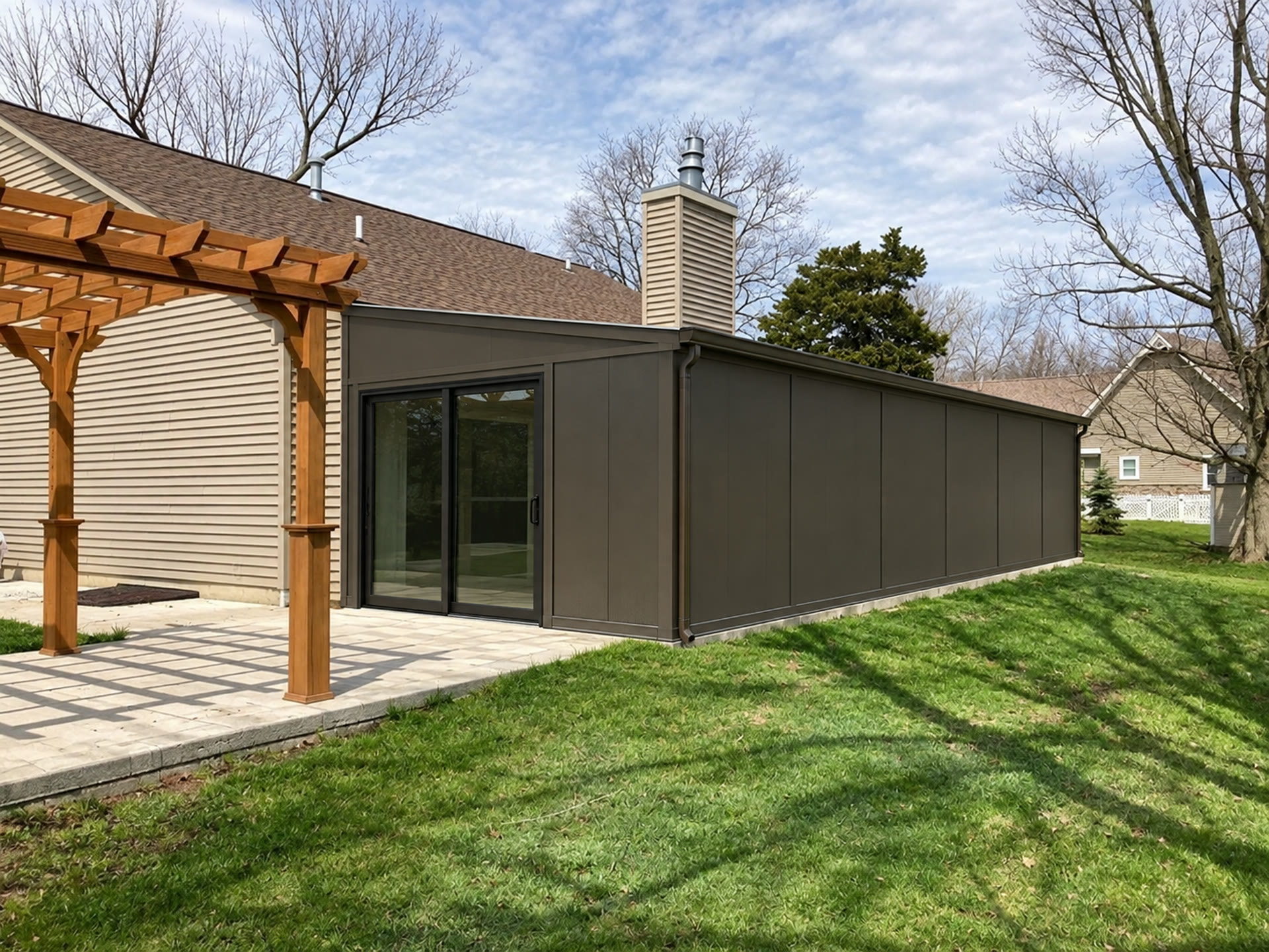 Dark-sided private gym addition attached to a home, seen from the backyard