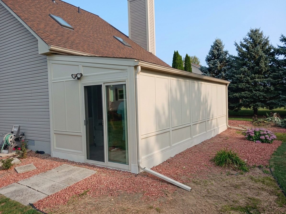 Residential addition with paneled exterior siding and a sliding glass door